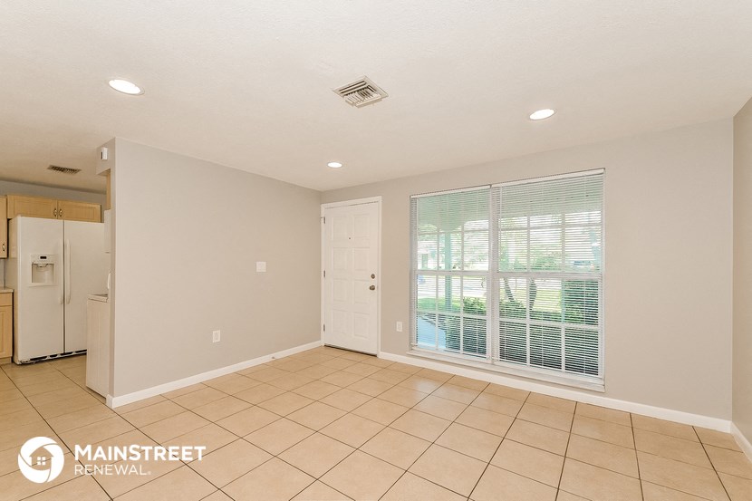 the living room has a large window and tile flooring