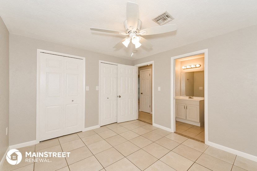 a master bathroom with white doors and a ceiling fan