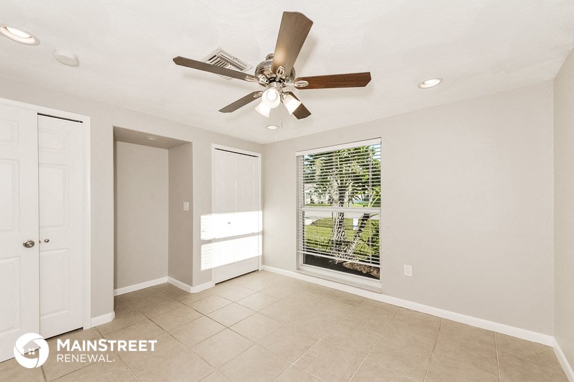 a living room with a ceiling fan and a window