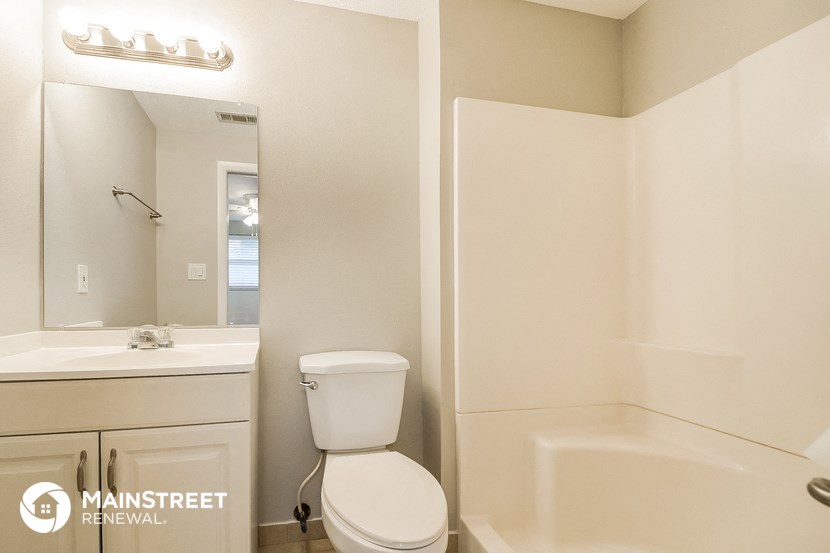 a bathroom with a toilet and a tub and a sink