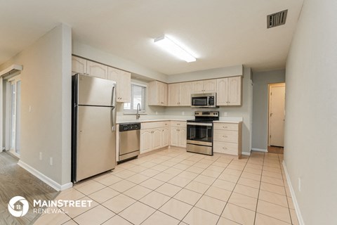 a large kitchen with white cabinets and stainless steel appliances