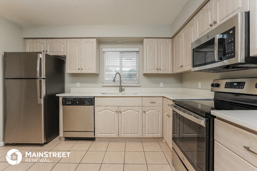 a kitchen with white cabinets and black appliances