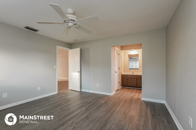 a living room with wood flooring and a ceiling fan