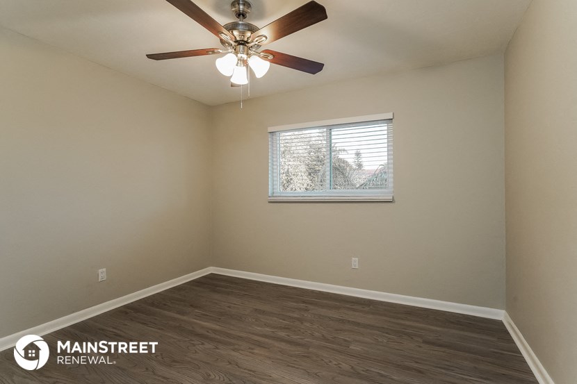 an empty room with a ceiling fan and a window