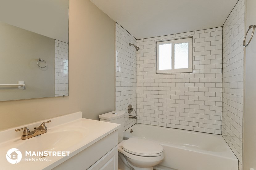a white bathroom with a tub and a toilet and a sink