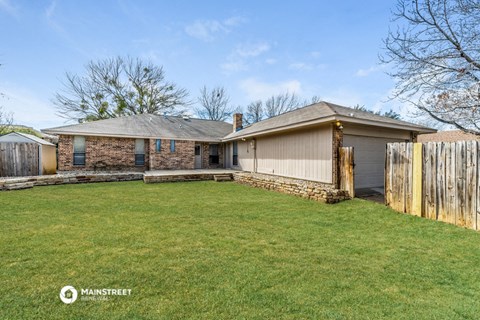 a brick house with a yard and a wooden fence