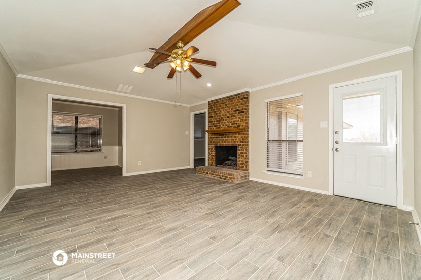 a living room with a fireplace and a ceiling fan