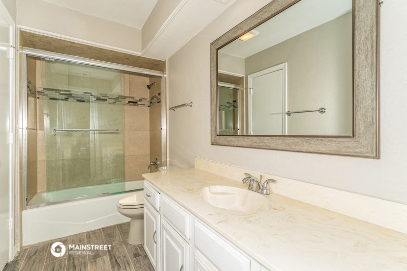 a bathroom with a large mirror and a shower and a sink