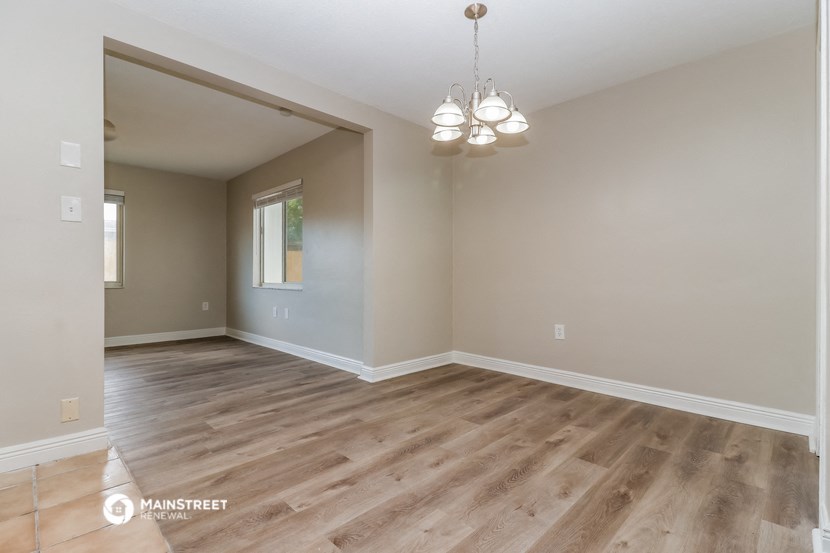the spacious living room with wood flooring and a chandelier