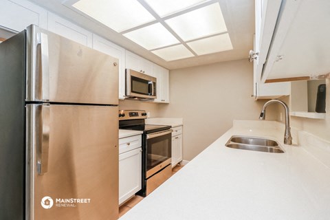 a kitchen with stainless steel appliances and a sink and a refrigerator