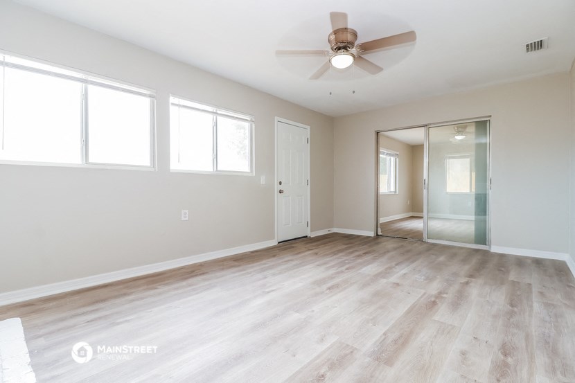 the living room of an empty house with a ceiling fan