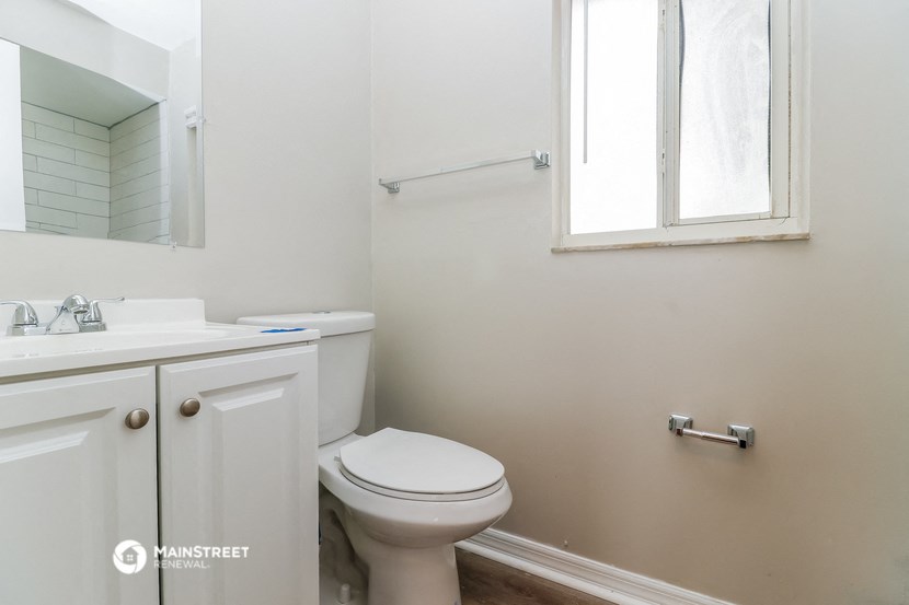 a bathroom with a toilet and a sink and a window