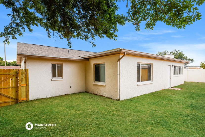 a white house with a yard and a wooden fence