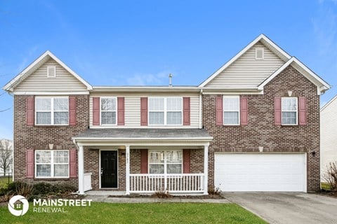 a brick house with red shutters and a white garage door