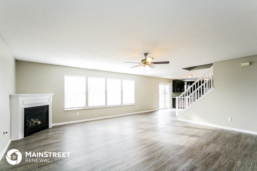 a living room with a fireplace and a ceiling fan