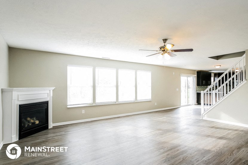 a living room with a fireplace and a ceiling fan