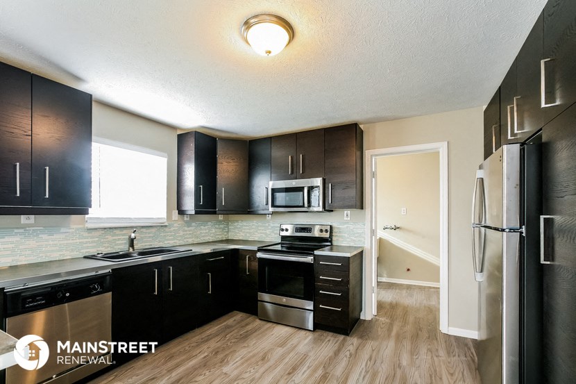a renovated kitchen with black cabinets and stainless steel appliances