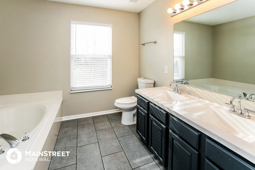 a bathroom with a tub and a sink and a toilet