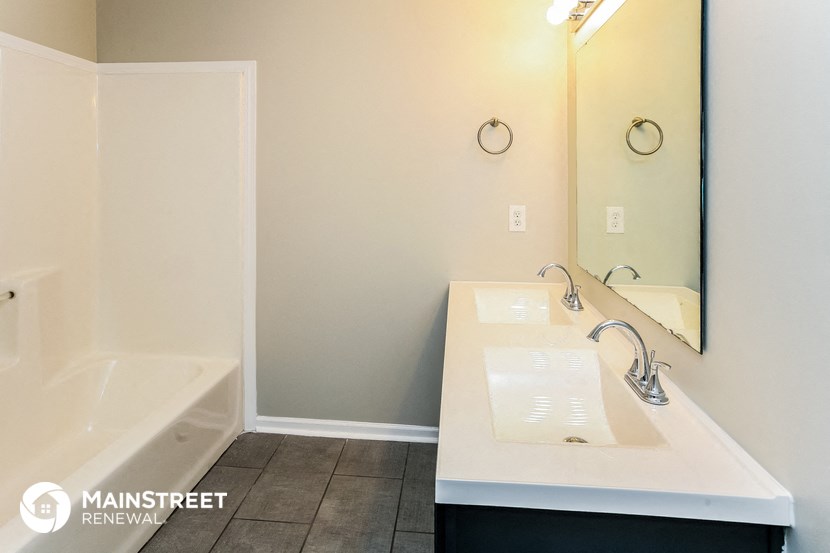 a bathroom with two sinks and a tub and a mirror