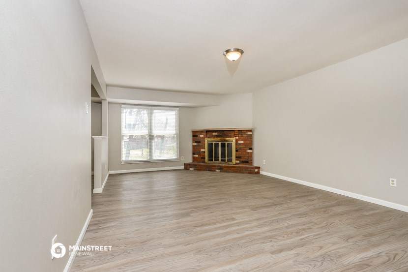 the living room of an empty house with a fireplace