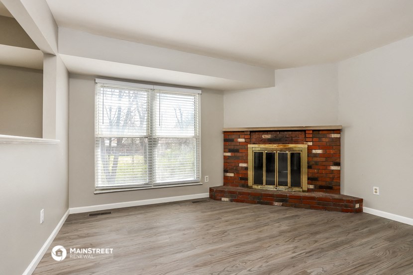 an empty living room with a fireplace and a window