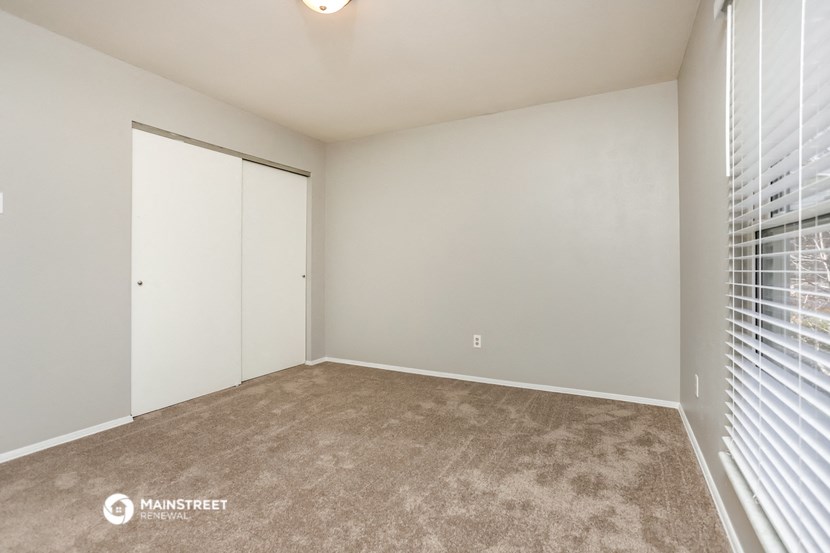 the spacious living room of a manufactured home with a large window and a closet