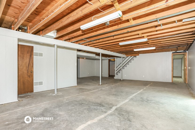 a large garage with exposed wood ceilings and a staircase