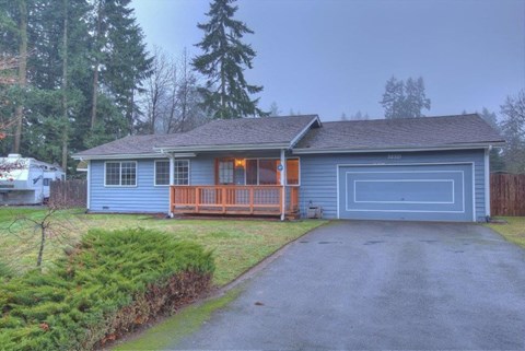 a blue house with a driveway and a blue garage door
