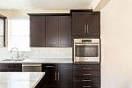 a kitchen with black cabinets and an oven and a sink