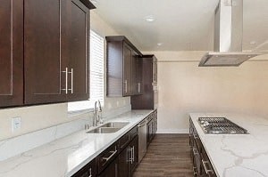 a kitchen with marble counter tops and wooden cabinets