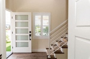 an empty house with a staircase and a white door
