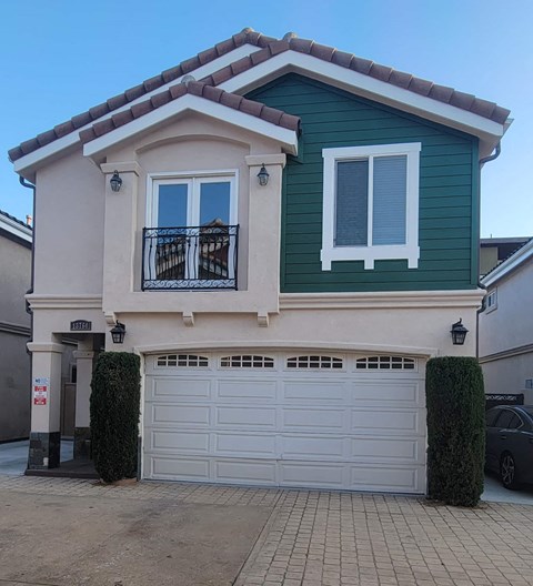 a white and green house with a garage door