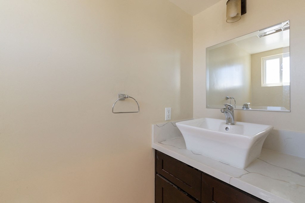 an empty bathroom with a sink and a mirror