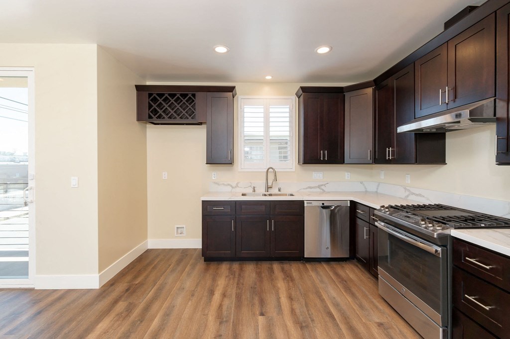 a kitchen with dark wood cabinets and stainless steel appliances