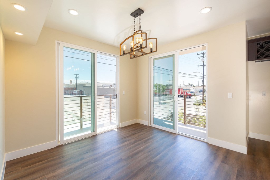 a living room with windows and a door to a balcony