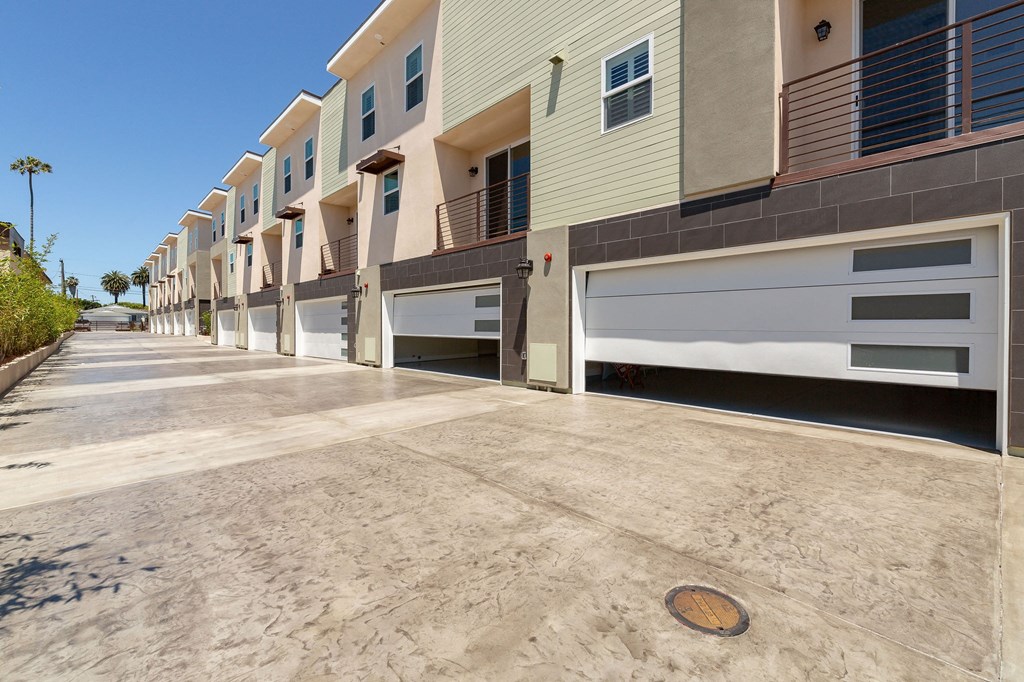 an empty parking lot in front of a building with a garage door