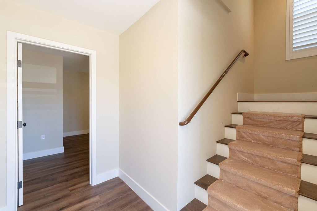 a view of a staircase in a home with white walls and wood floors