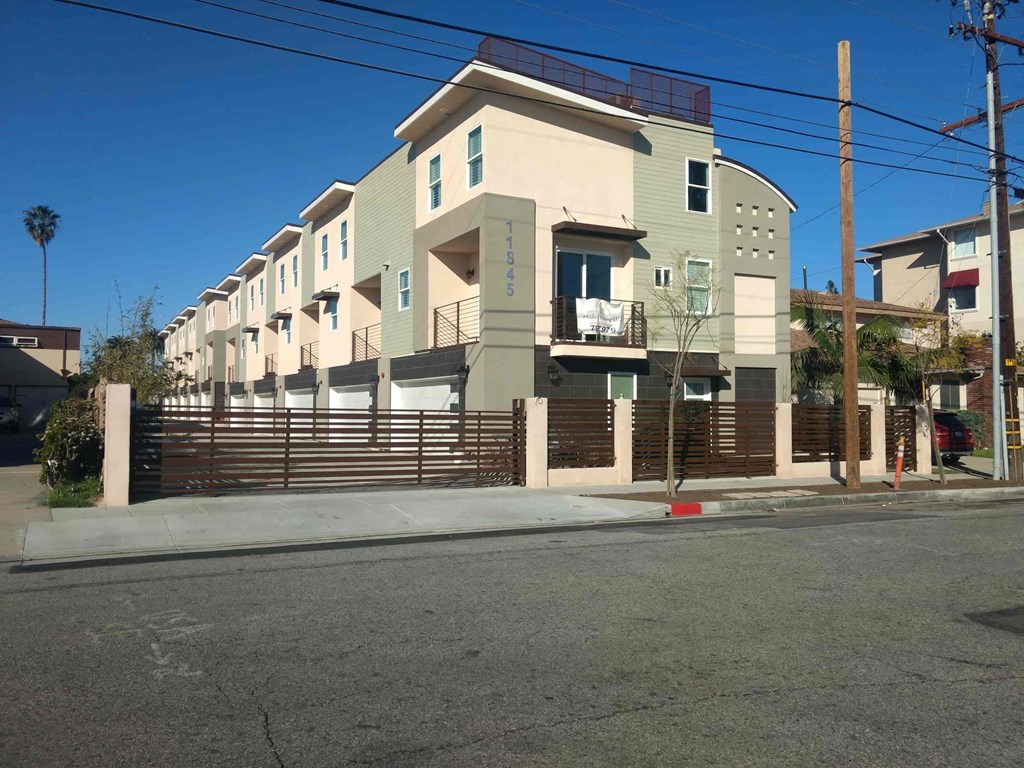 a row of houses on a street corner with a fence