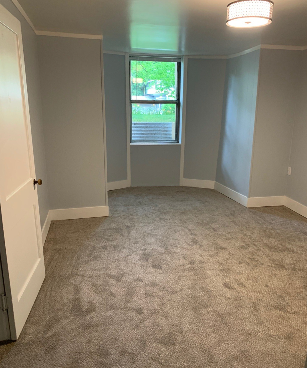 a living room with carpet and a window