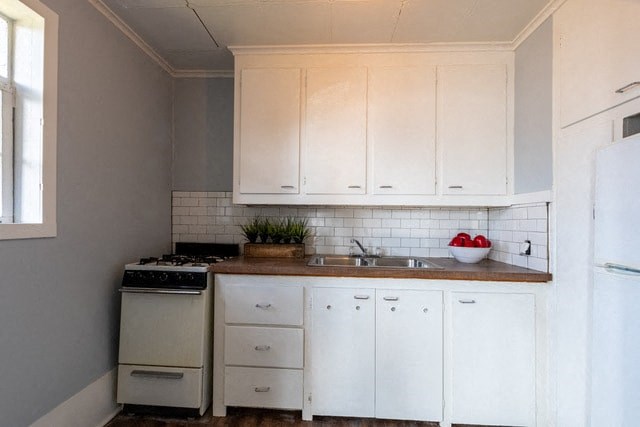 a kitchen with white cabinets and a stove and a sink