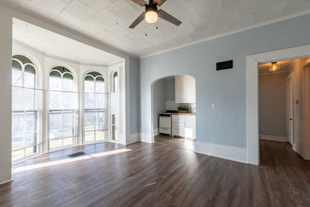 an empty living room with large windows and a ceiling fan