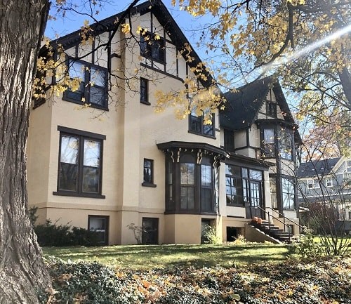 a large house with a tree in front of it