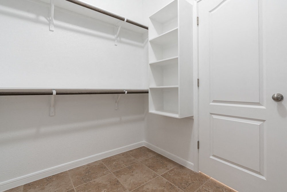 a walk in closet with shelves and a white door