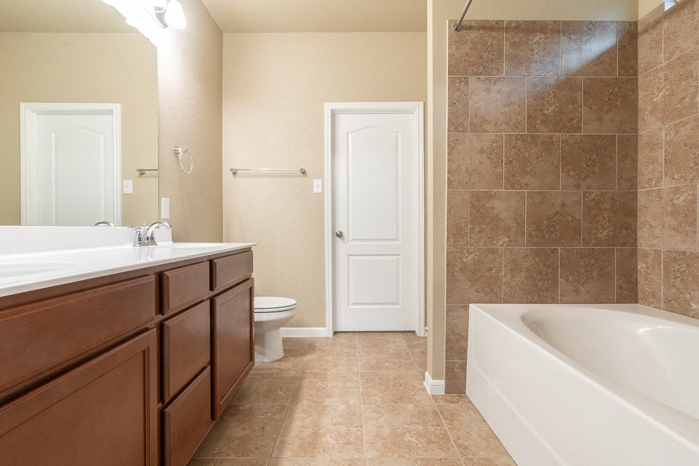 a bathroom with a tub and a sink and a toilet