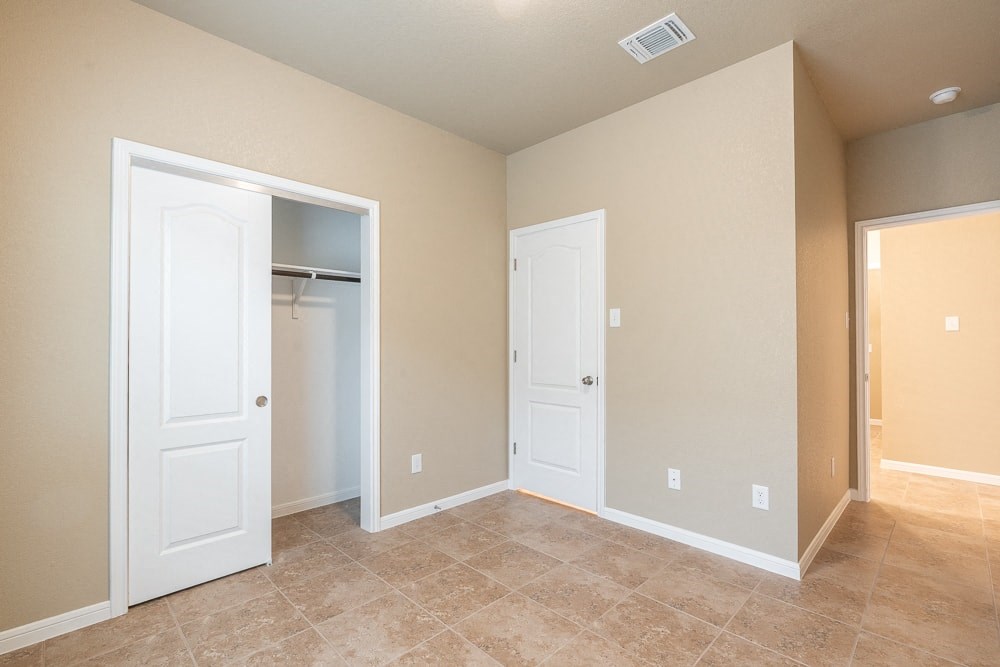 an empty room with two doors and a closet