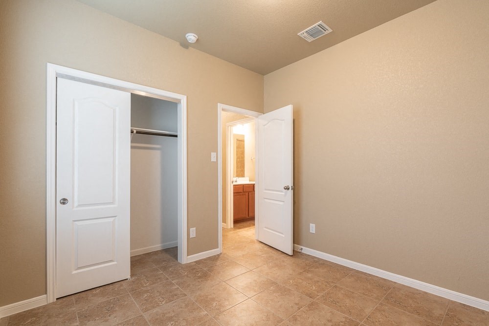 a bedroom with a closet and a door to a bathroom