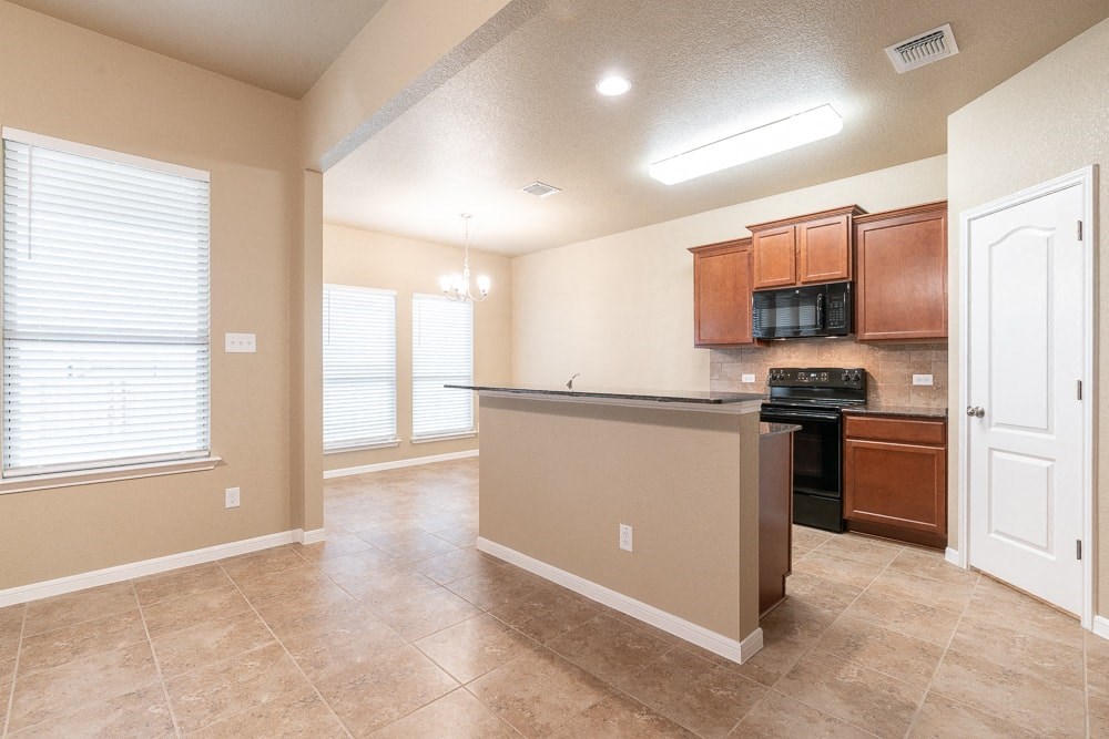 an empty kitchen with a counter top in the middle