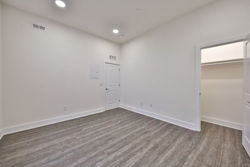 an empty living room with white walls and a door to a closet