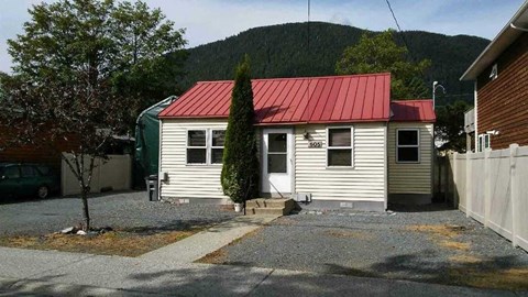 a small white house with a red roof