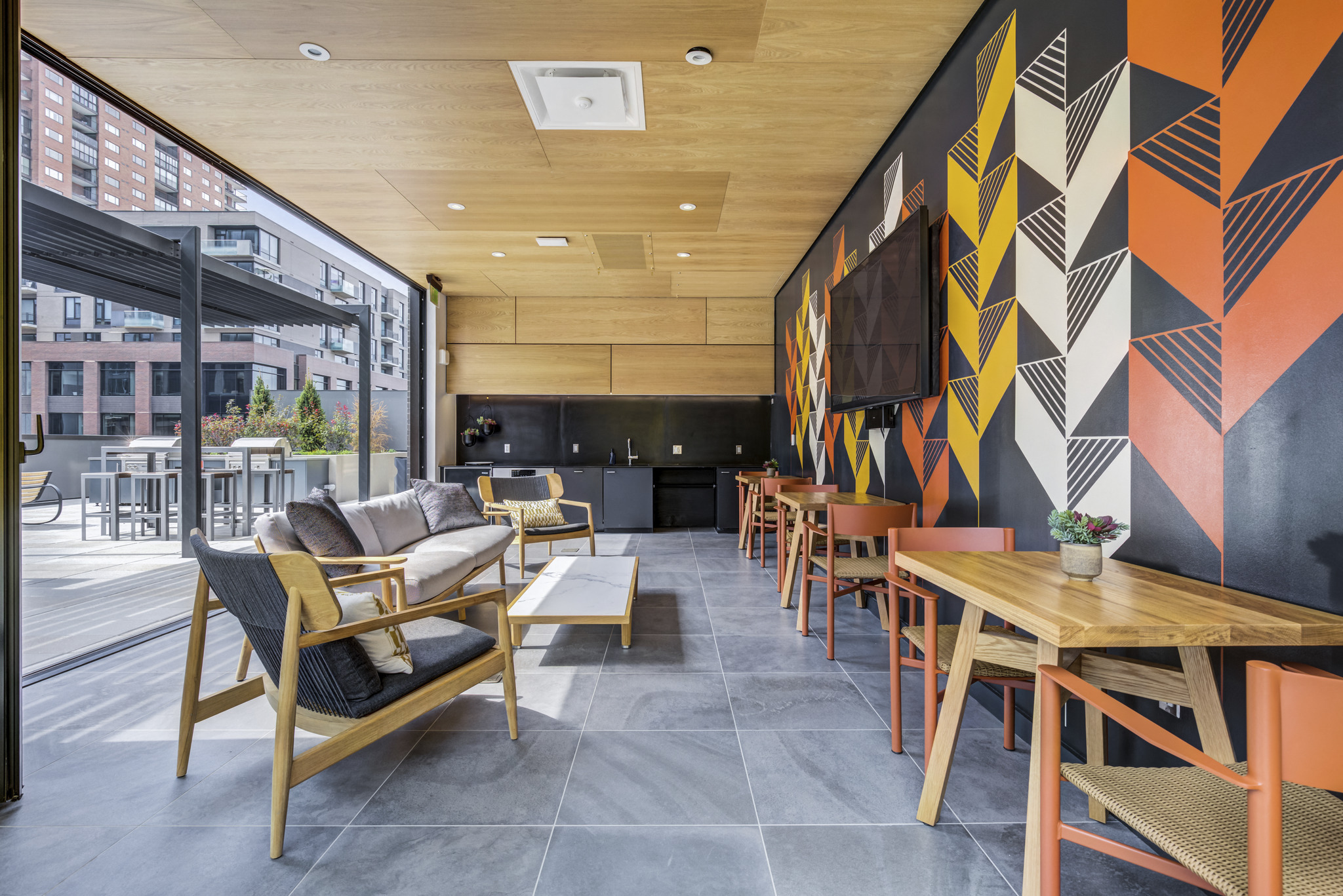a dining room with tables and chairs and a wall with geometric patterns